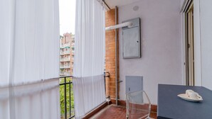 Un balcone con vista su edifici, un tavolo con una tazza e una sedia.