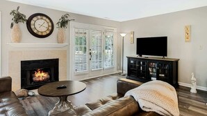 Una sala de estar con chimenea, televisor y sofá.