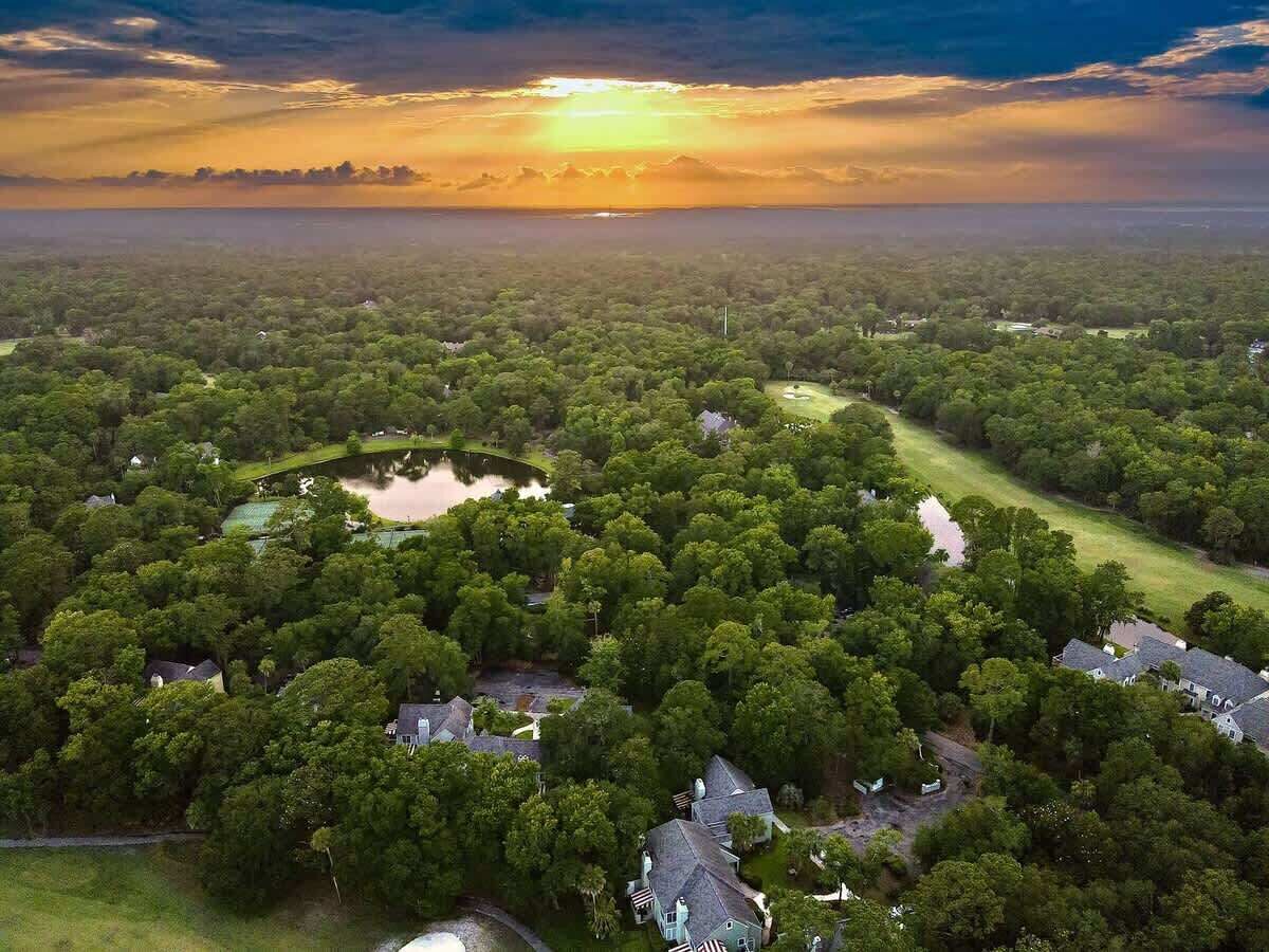 An aerial view of a residential area with houses, a pond, and a golf course.