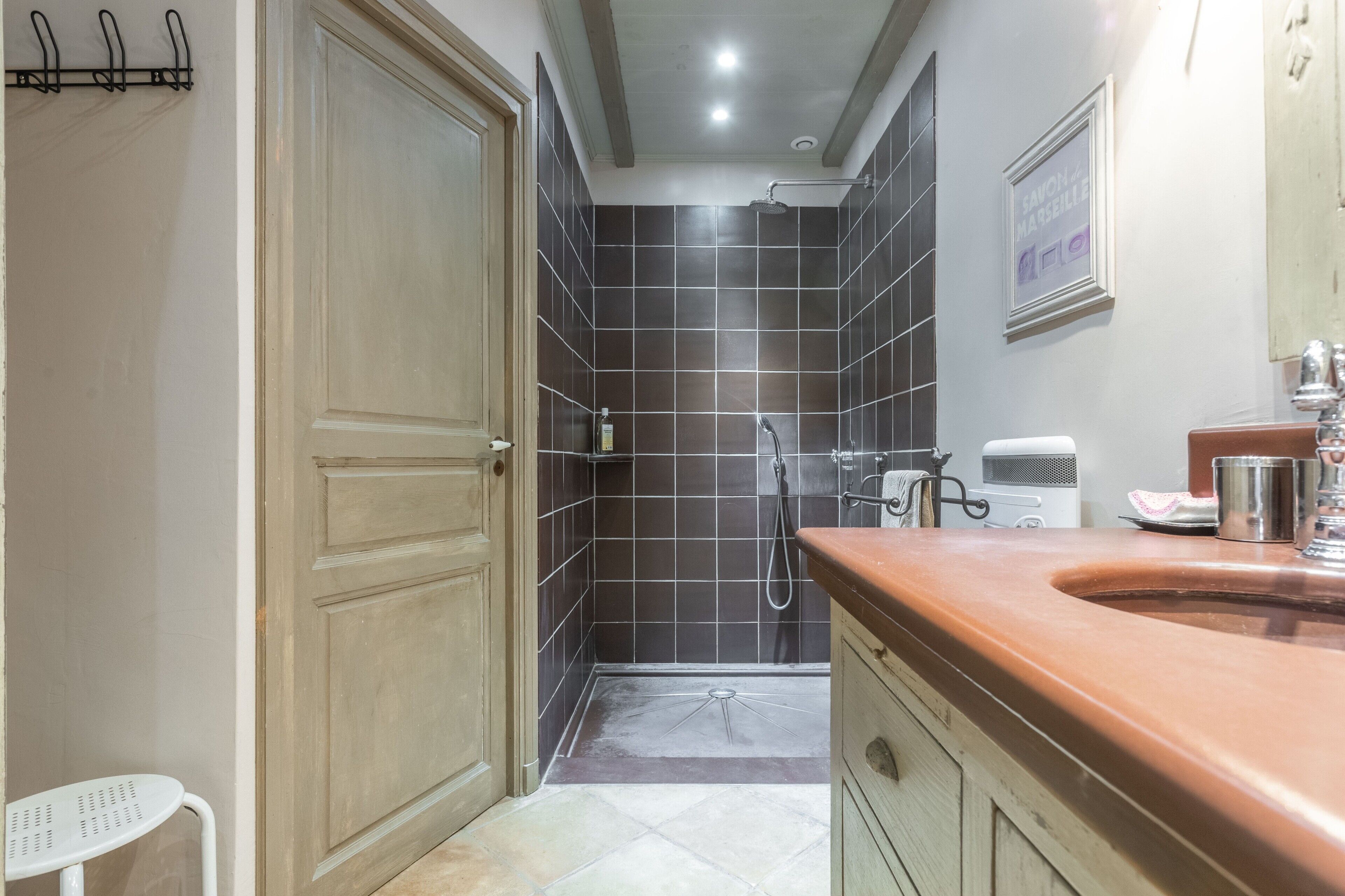 Une salle de bain équipée d’une douche, d’un lavabo, d’un miroir et d’un porte-serviettes.
