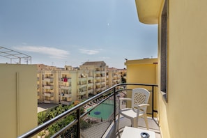 A balcony with a view of a residential area, including a swimming pool and multiple buildings. - Charming Rina Sea Studio Apartment - Central Air-con & Wifi Sleeps 2 Persons (Alghero)