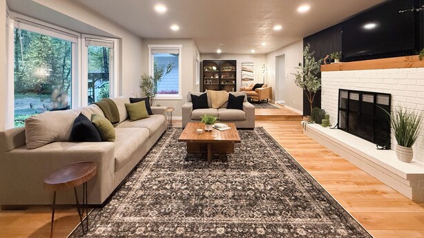 Un salon moderne avec un canapé, des fauteuils, une table basse et une cheminée.