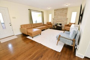A living room with a sectional sofa, a small table, and a fireplace. - Walkable to Notre Dame! Cozy 2 bedroom home(426) (South Bend)