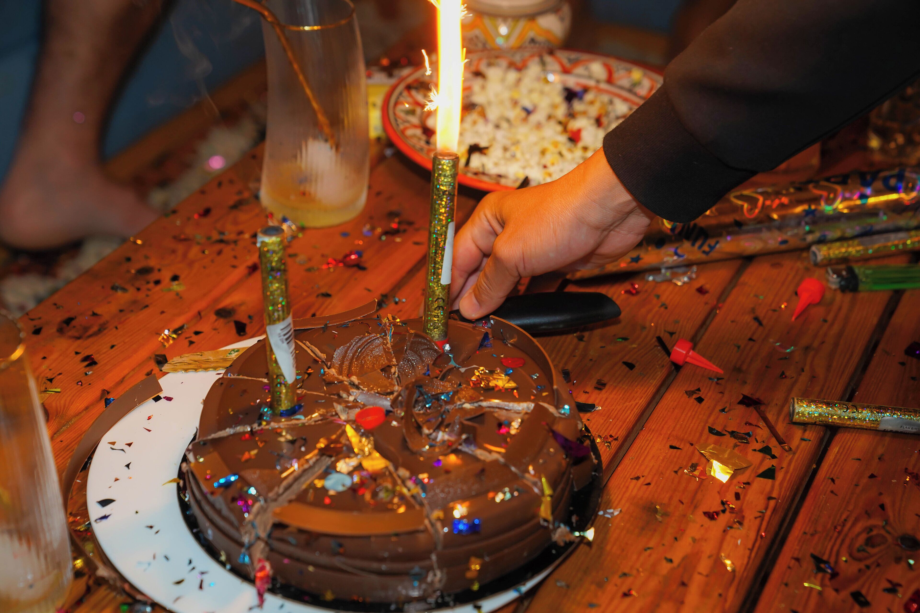 A birthday cake with candles on a wooden table.
