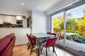 A modern kitchen with white cabinets and a dining area with a table and chairs.