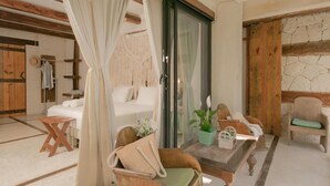 A cozy room with a bed, a wooden chair, a small table with a plant, and a curtain. - La Casa de Mia Tulum (Tulum)