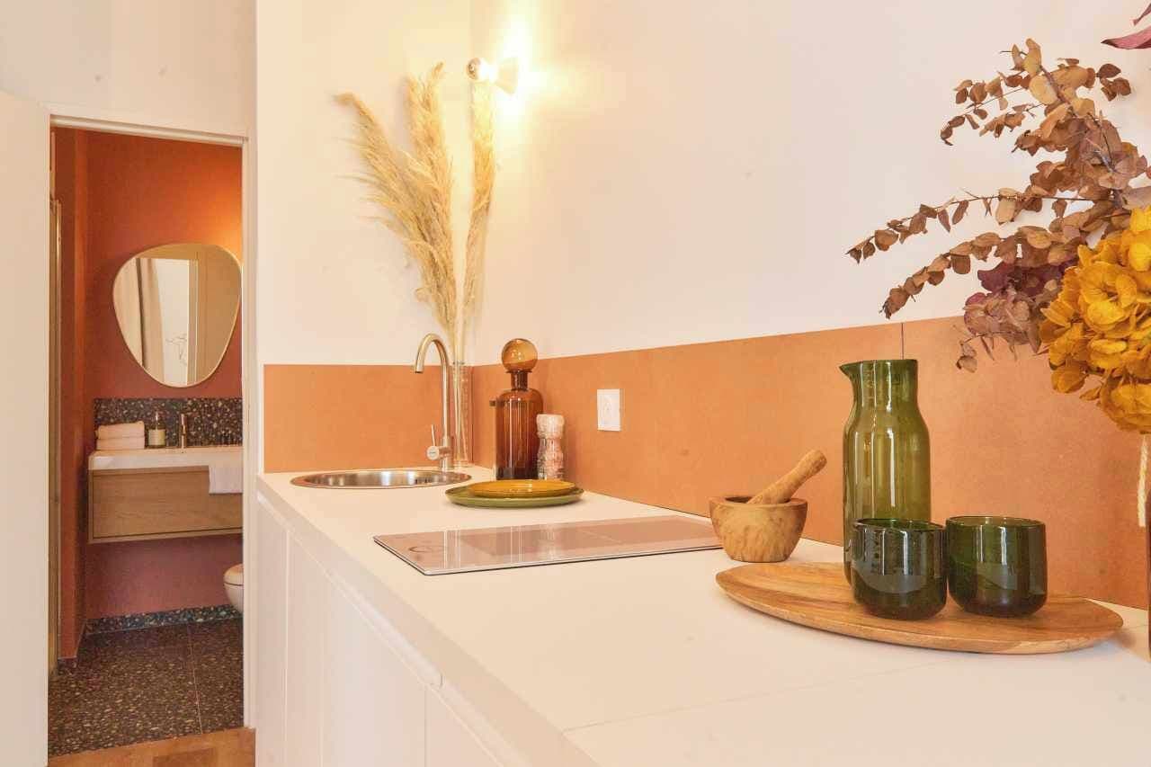 A modern bathroom with a white sink, mirror, and a wooden vanity.