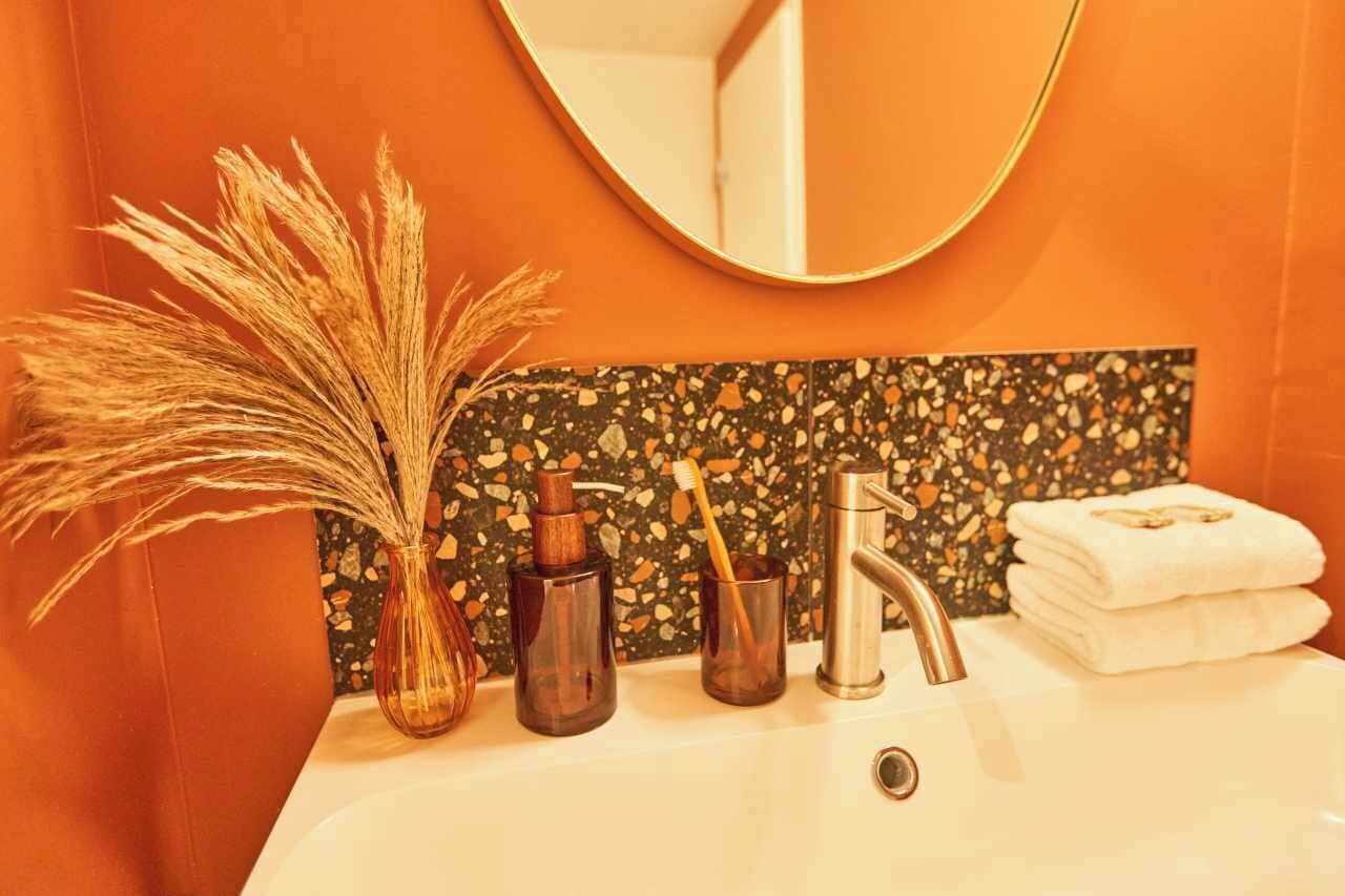 A bathroom with a sink, mirror, and toiletries.
