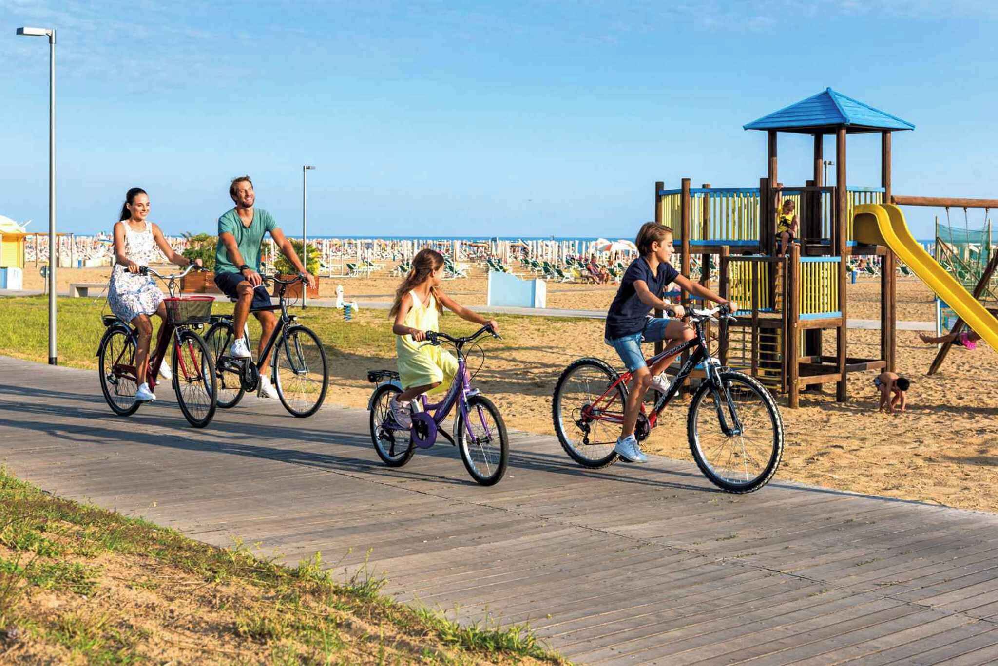 Um calçadão de madeira com pessoas andando de bicicleta.