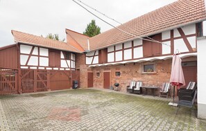 A courtyard with a brick wall, wooden gates, and outdoor seating. - Villa Filimena Monteurunterkunft Gründau (Gruendau)