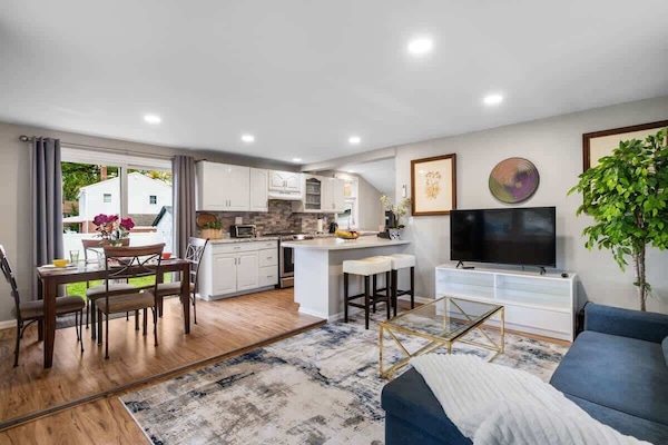 Step into a bright, open-concept home designed for comfort and connection. Large windows fill the room with natural light, while thoughtful touches—from the plush sofa to the fully equipped kitchen—make you feel right at home.