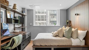 Un dormitorio moderno con cama, escritorio y estantería.
