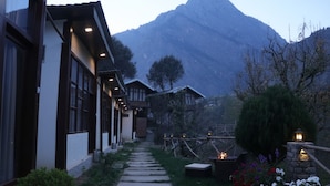 A pathway leading to a building with a mountain in the background. - SnugBug Kasol (Kasol)