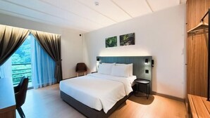 Une chambre d’hôtel moderne équipée d’un lit, d’un bureau, d’une chaise, d’une petite table et d’une armoire.