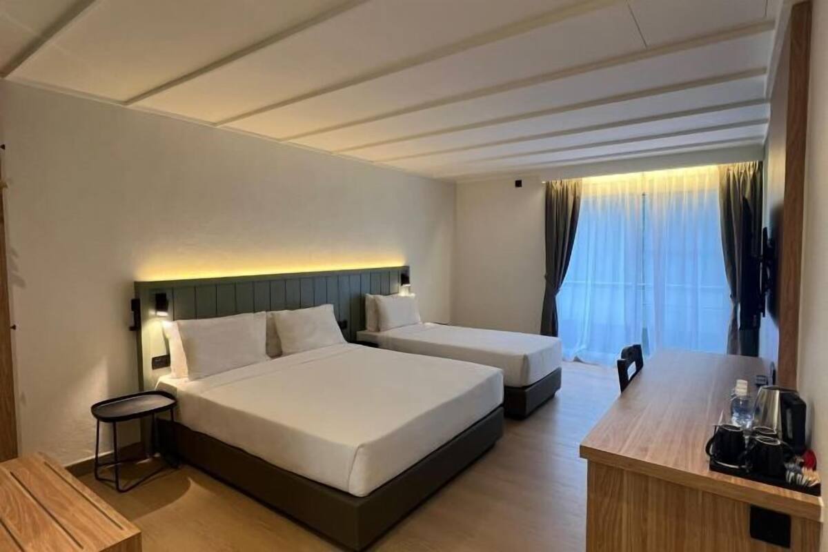 Een hotelkamer met twee bedden, een bureau en een stoel.