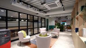 Un espace de bureau moderne avec des cloisons en verre, du mobilier blanc et un panneau de la British Heart Foundation.