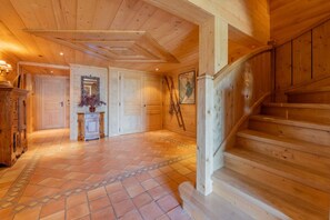 Ein Holzinnenraum mit Treppe, Kamin und Fliesenboden.