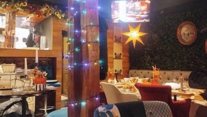 A cozy restaurant with wooden decor, string lights, and a star decoration.