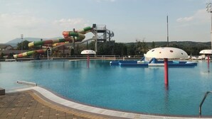 A swimming pool with a water slide and a dome-shaped structure.