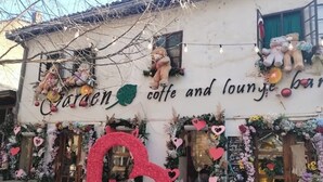 A cafe with a large heart-shaped decoration and a sign that reads "Caren coffee and lounge bar".