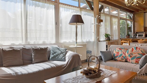 A cozy living room with a sofa, a wooden coffee table, and a lamp.