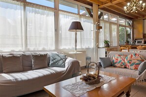 A cozy living room with a sofa, a wooden coffee table, and a lamp. - Gite 2 – Chez Balum, 3 km from Lourdes in the Hautes-Pyrénées (Lézignan)