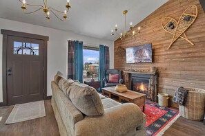 A cozy living room with a fireplace, a sofa, a coffee table, and a television. - 3BD/2BA, Hot Tub, Pickleball Court, Arcade, Wifi, Laundry, 10 min. to Park City (Kamas)