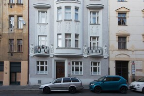 A building with a central entrance, multiple windows, and balconies with statues. - Beautifully Designed 1-bed Apartment by Vy Ehrad (Prague)
