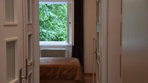 Un dormitorio con cama, ventana y radiador.