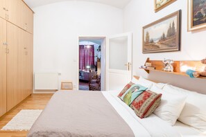 A bedroom with a large bed, wooden wardrobe, and a painting on the wall. - Premium Apartment With Private Terrace in Zizkov (Prague)