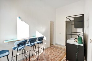Huoneessa on työpöytä, tuoleja, peili ja patteri.