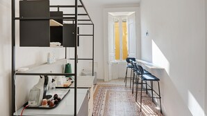 A modern room with a built-in desk, chairs, a radiator, and a patterned rug. - Antica Dimora Deluxe with Balcony, Wi-Fi and Air Conditioning (Napoli)