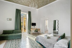 A bedroom with a bed, a sofa, a desk, and a chandelier. - Antica Dimora Deluxe with Balcony, Wi-Fi and Air Conditioning (Napoli)