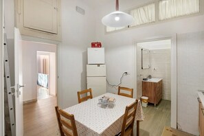 Una cucina compatta con frigorifero, lavello e mobiletto in legno.