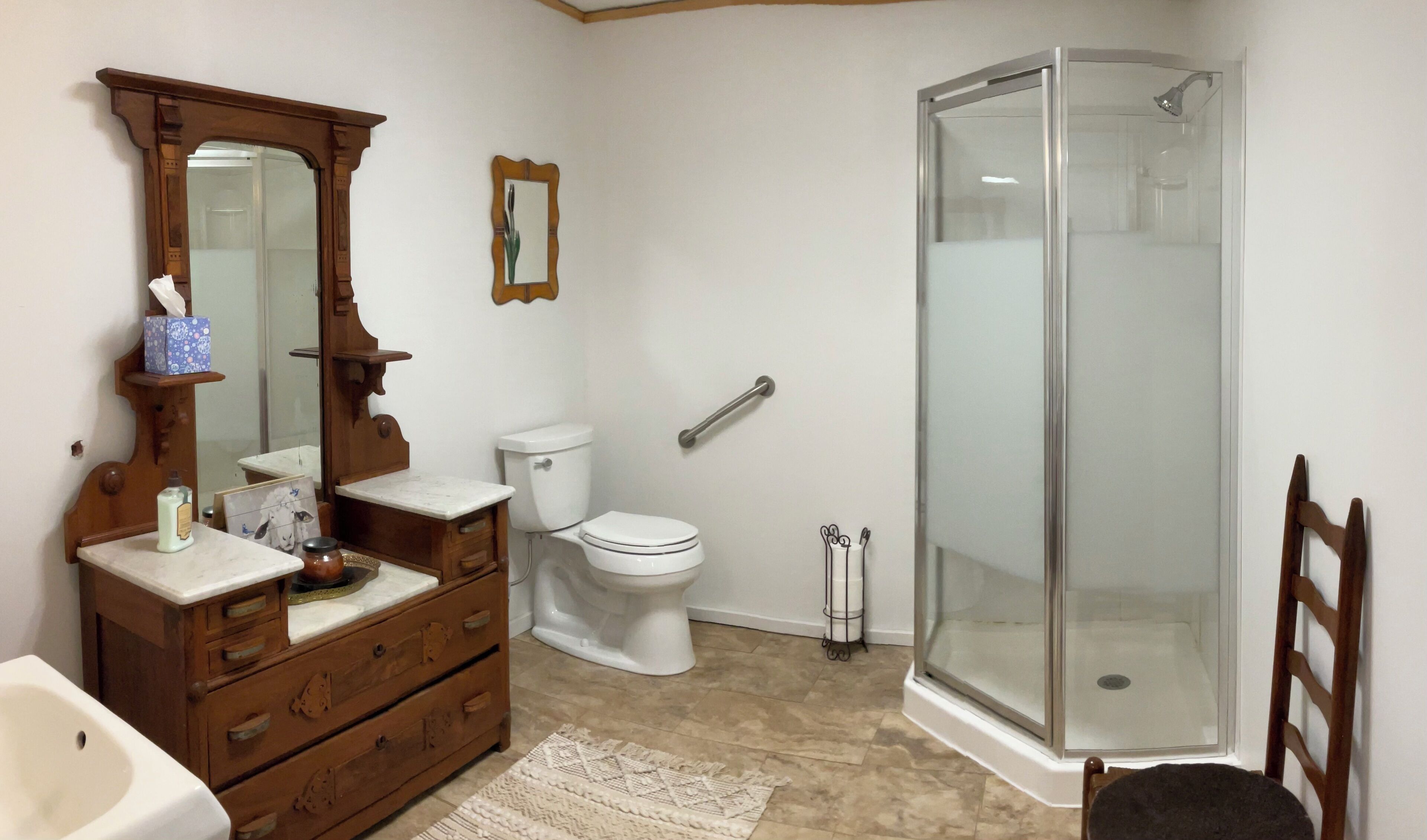 Une salle de bain avec un meuble-lavabo en bois, des toilettes, une douche en verre et un miroir.