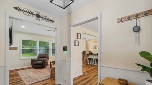 A spacious living area with a brown leather chair, a patterned rug, and a wooden dining table. - Magnolia Retreat 4BR 3BA Home (Hattiesburg)