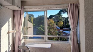 A room with a large window, a ceiling fan, and a bed. - Charming 1 and a half-bedroom apartment in beautiful Punta del Este. 4 people (Punta del Este)
