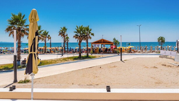 A beach with a covered seating area, palm trees, and a clear blue sky. - Adriatic Seaview Suites by PS (Durrës)