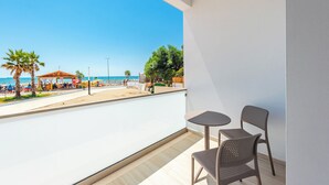 A balcony with a view of the beach, a table, and two chairs. - Adriatic Seaview Suites by PS (Durrës)
