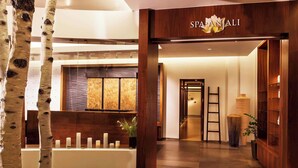 Een spa interieur met een receptiebalie, houten details en een groot raam.