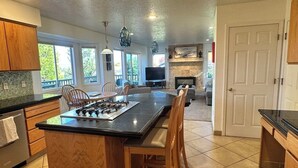 A spacious kitchen with a central island, wooden cabinets, and a dining area. - Columbia View Retreat, Spacious Furnished Home in Argay Terrace,Portland Airport (Portland)