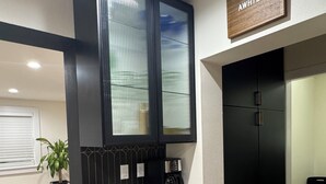 Una cucina moderna con mobili neri, un piano di lavoro bianco e un cartello di benvenuto.