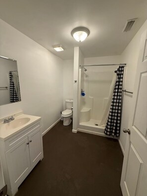 Ein Badezimmer mit weißem Waschbecken, WC und Dusche.