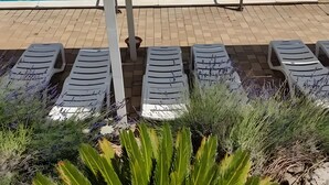 Ein Poolbereich mit Liegestühlen.