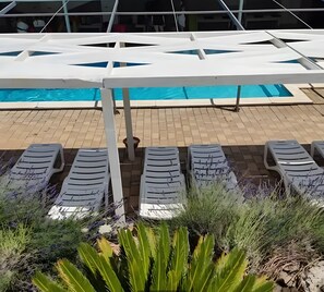 A poolside area with lounge chairs and a pool. - Villa 'Oasi Torre Di Mastro' with Pool (Conversano)