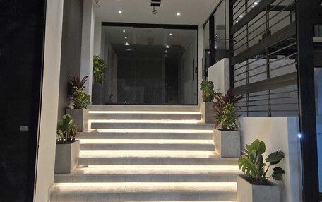 A modern staircase with illuminated steps leading to a dark interior.