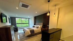 Quarto moderno com cama, mesa de cabeceira e área de escritório.