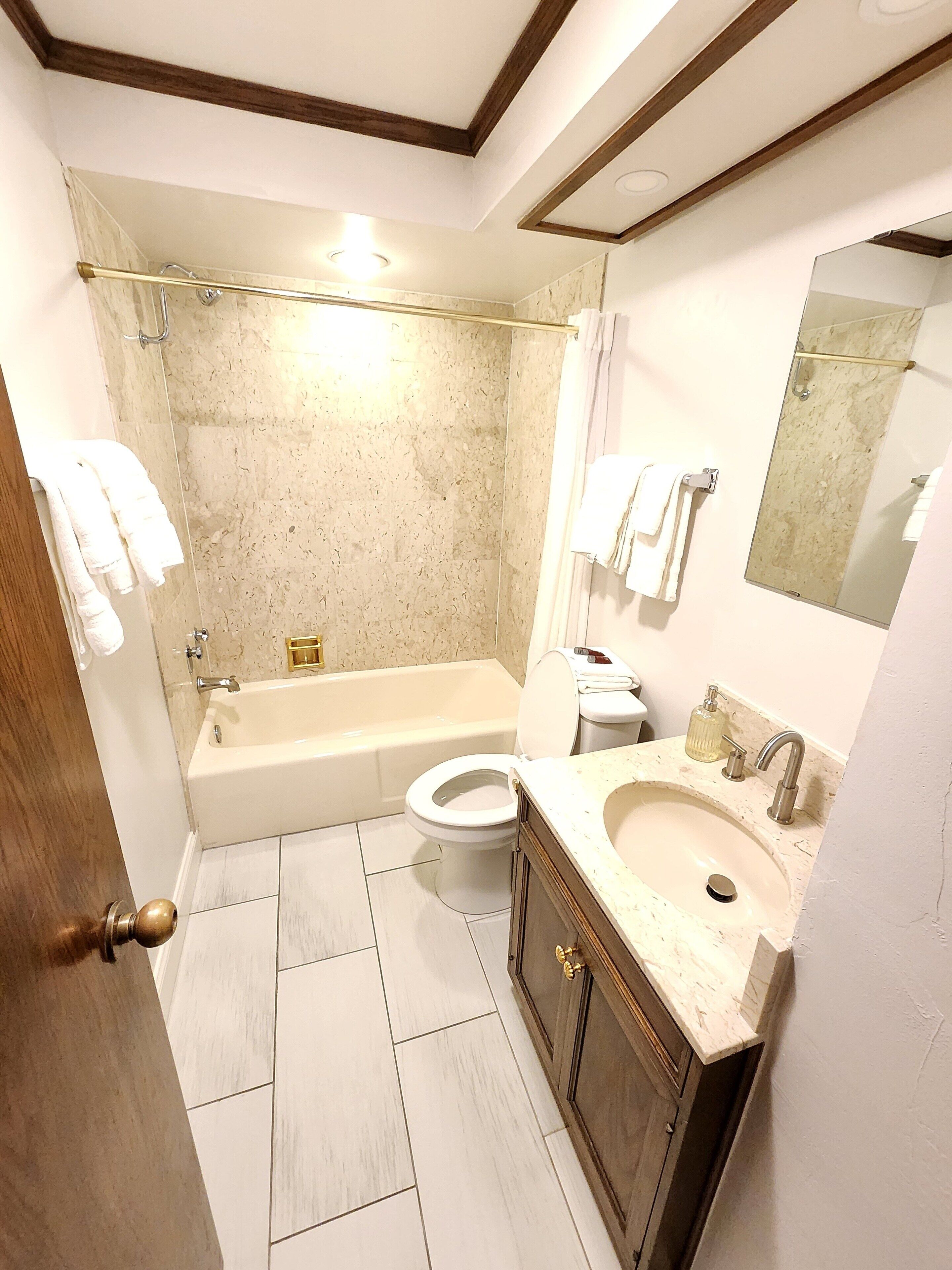 Un baño con bañera, inodoro y lavamanos.