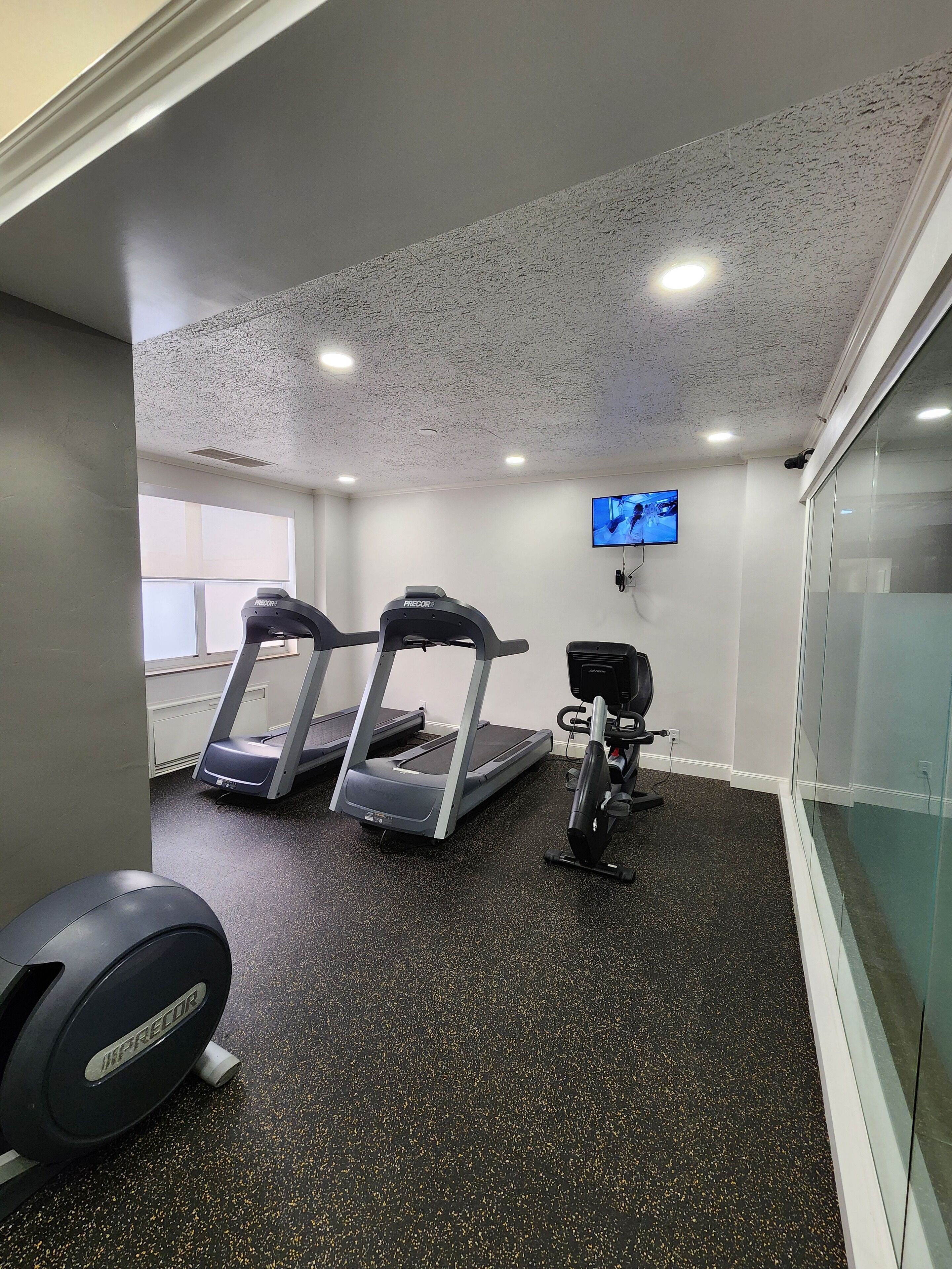A gym with treadmills, a stationary bike, and a weight bench.