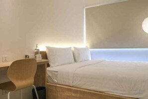 A hotel room with a bed, a desk, and a chair. - Teduh Simatupang (South Jakarta)